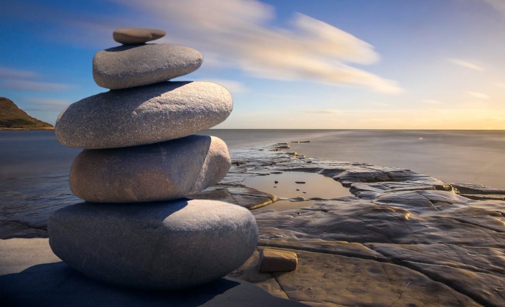 stacked-of-stones-outdoors-289586 A serene stack of stones on the rocky seashore during a peaceful sunrise, embodying balance and zen.